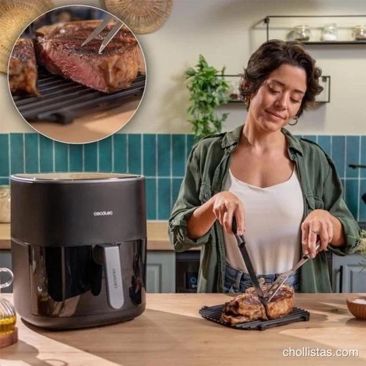 Mujer cortando un chuletón preparado en la placa de grill junto a la freidora de aire Cecotec